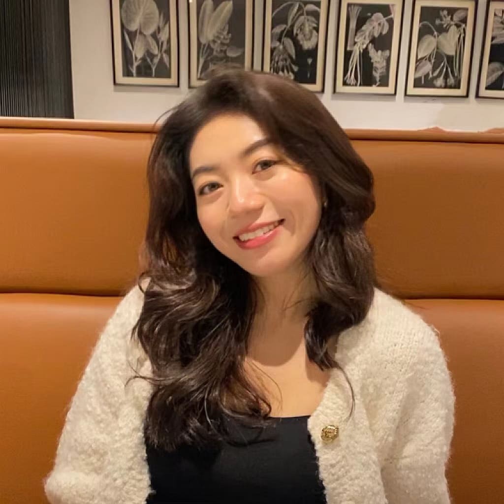 A smiley woman with pictures in the background