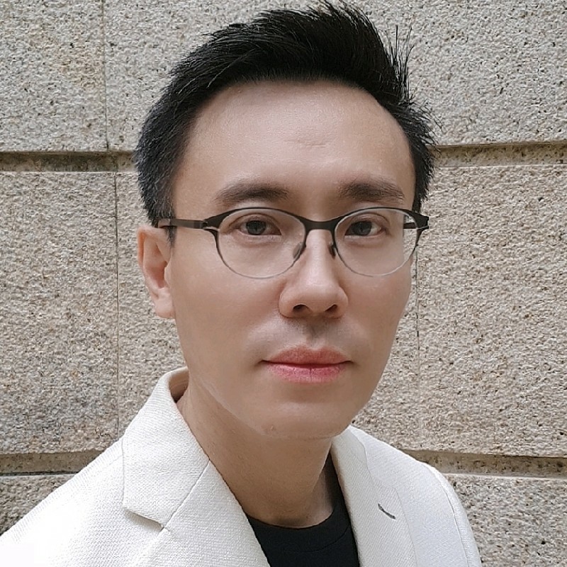 A man with glasses and white suit