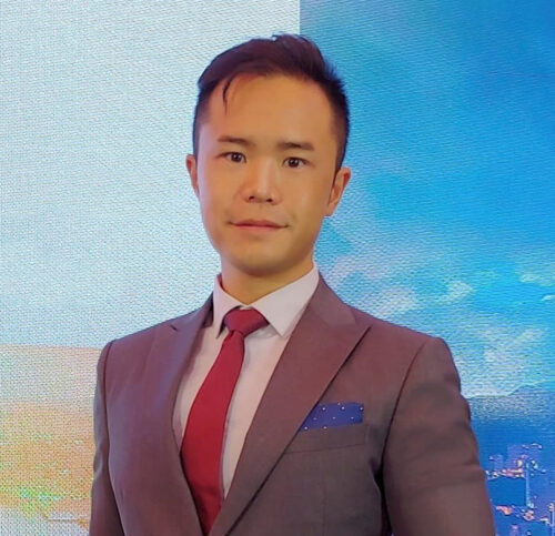 A man is wearing red tie with blue wall on the background
