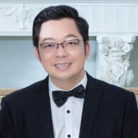 A man with glasses is wearing black bow tie